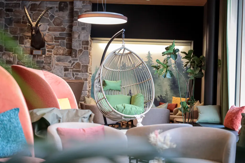 Gemütliche Lounge im AVES Savognin mit Hängesessel, Naturmaterialien und warmem Licht