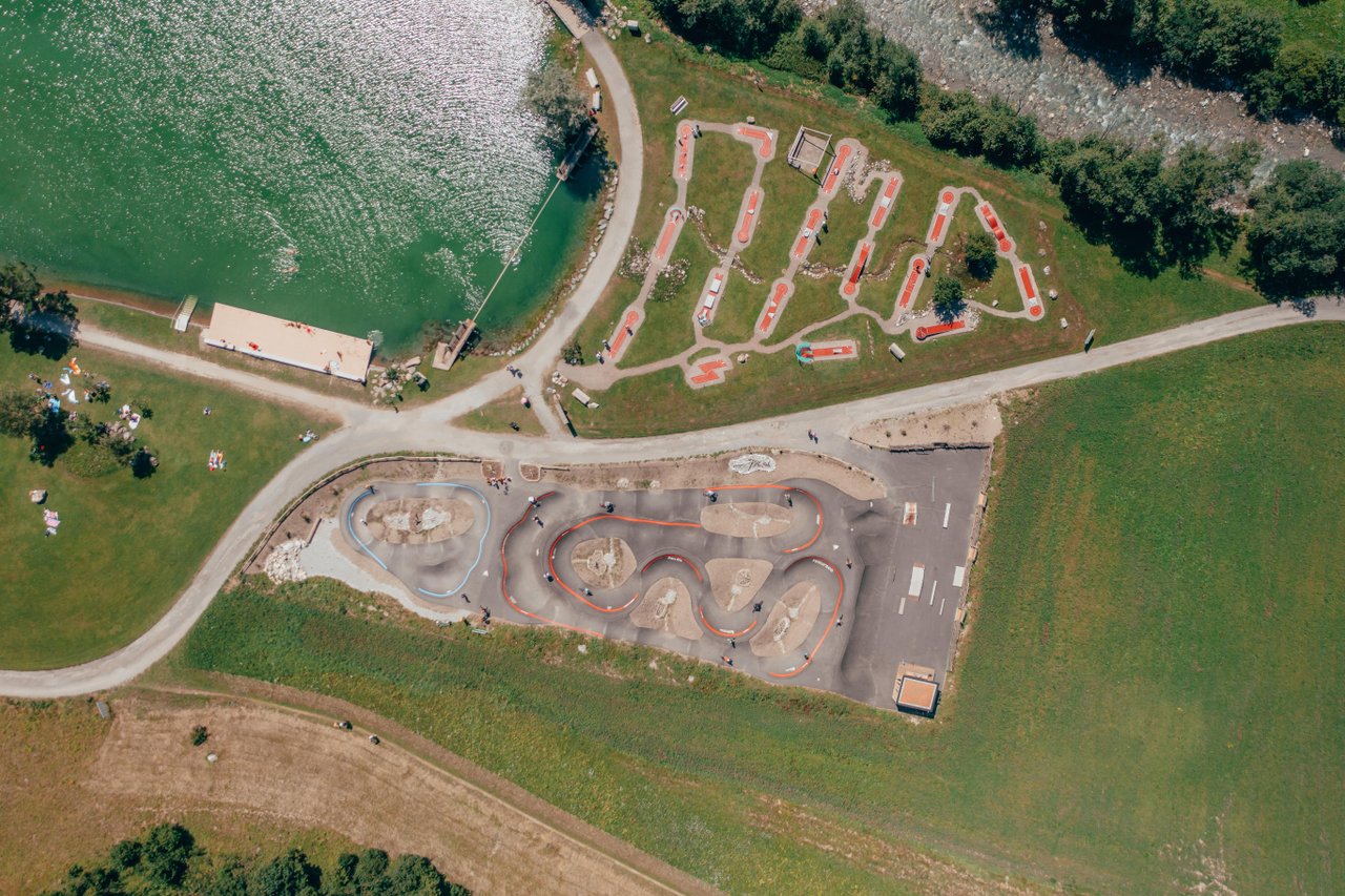 Luftaufnahme des Bikeparks mit Pumptracks und Mini-Golf in Savognin mit See Lai Barnagn