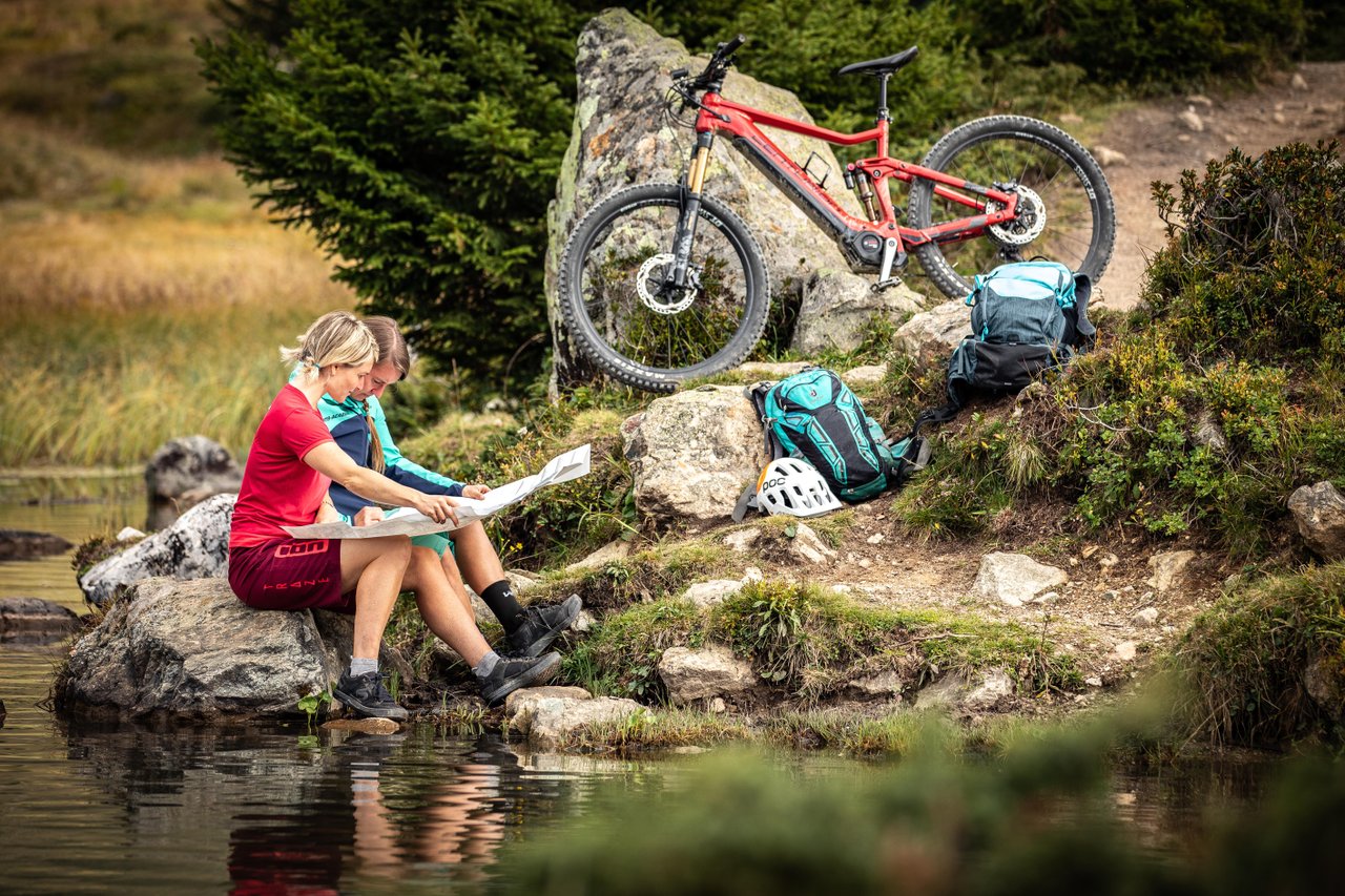 Biken in der Natur rund um Savognin mit Pause am Wasser und Blick auf die Route
