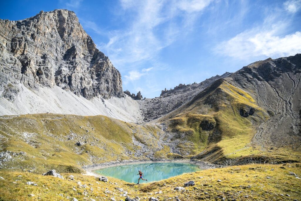 Trailrunning entlang eines alpinen Bergsees in der Berglandschaft rund um Savognin