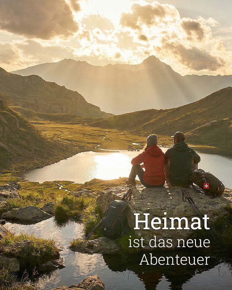 Pärchen sitzt auf einem Felsen und geniesst den Sonnenuntergang über einem Bergsee mit dem Schriftzug «Heimat ist das neue Abenteuer»